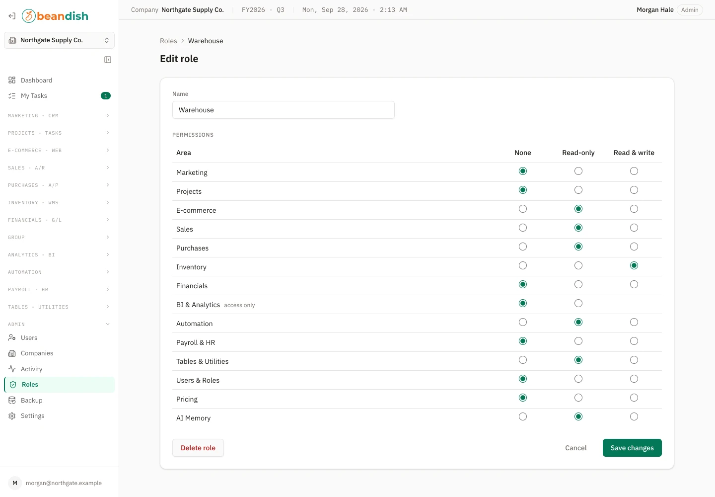 The edit role form for a warehouse role: the role’s name above its permissions, each area of the product — marketing, projects, e-commerce, sales, purchases, inventory, financials, BI & analytics, automation, payroll & HR, tables & utilities, users & roles, pricing and AI memory — set to None, Read-only or Read & write, with Delete role, Cancel and Save changes